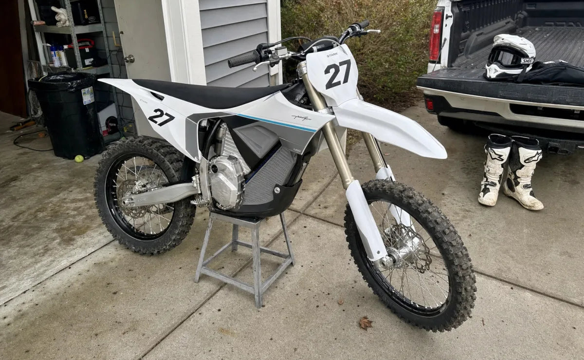 Stark Future Varg with OEM-style race graphics on a residential driveway