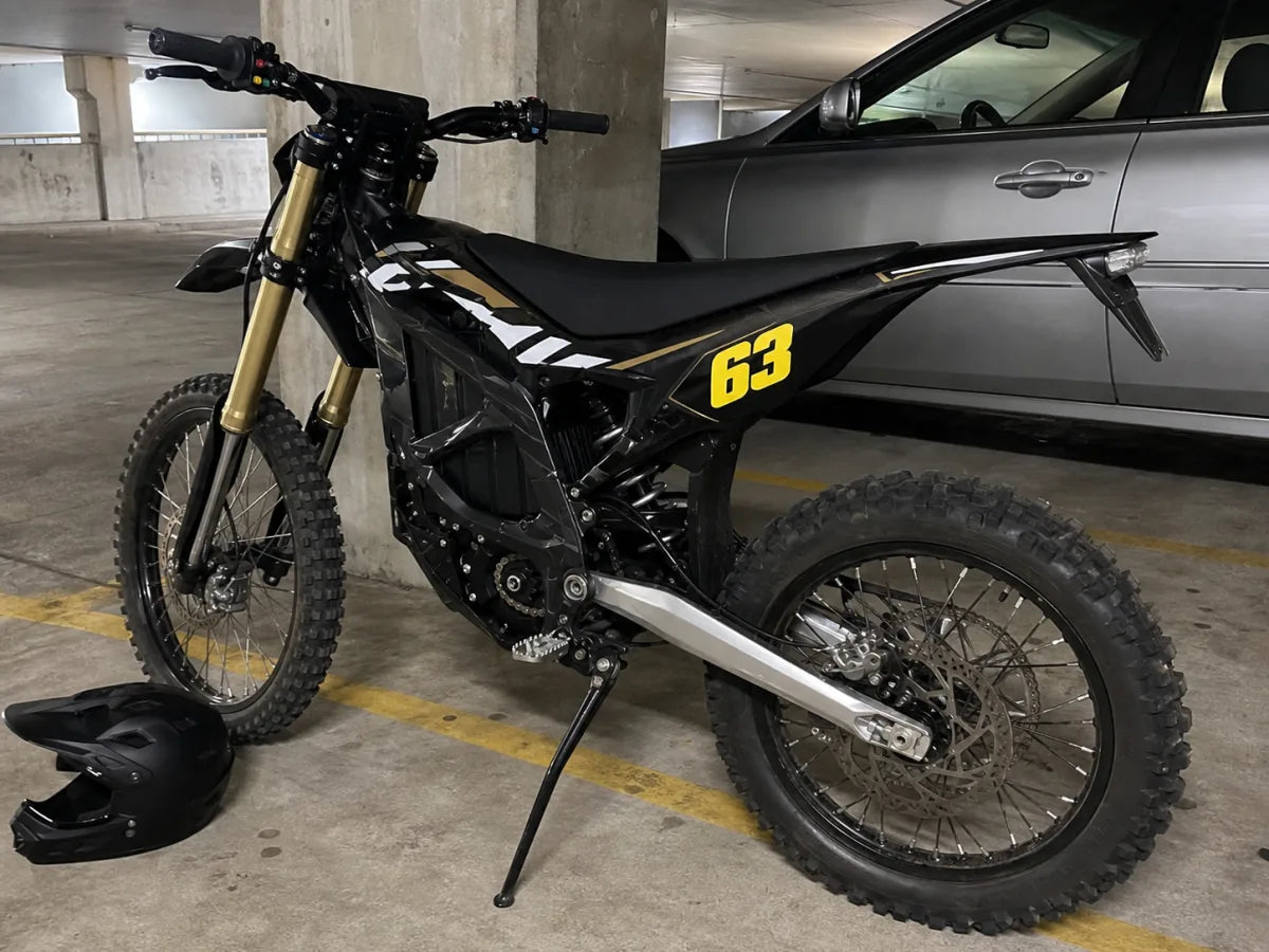 Surron Ultra Bee with privateer race graphics in a parking garage