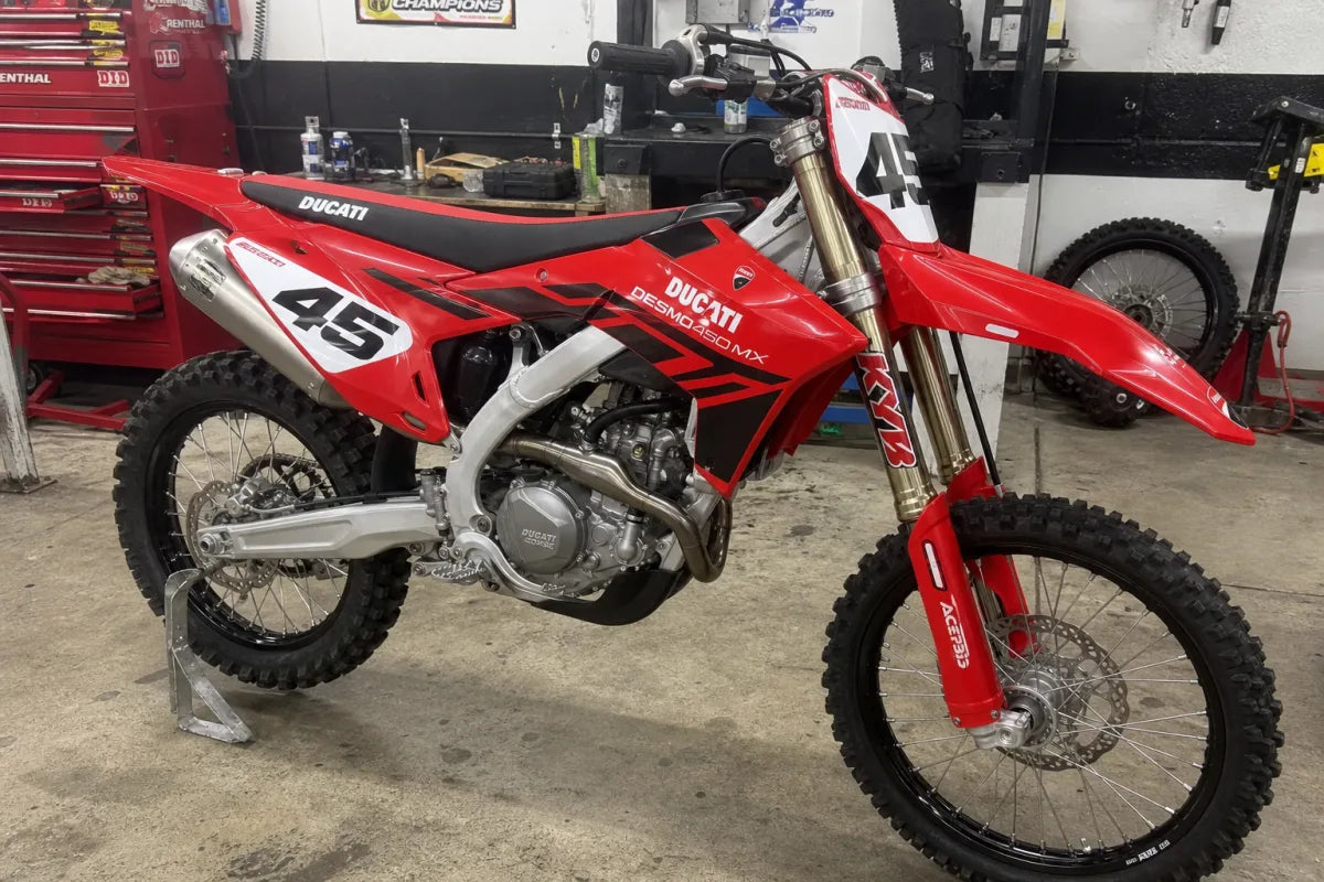 Ducati Desmo450 MX with OEM-style race graphics in a workshop